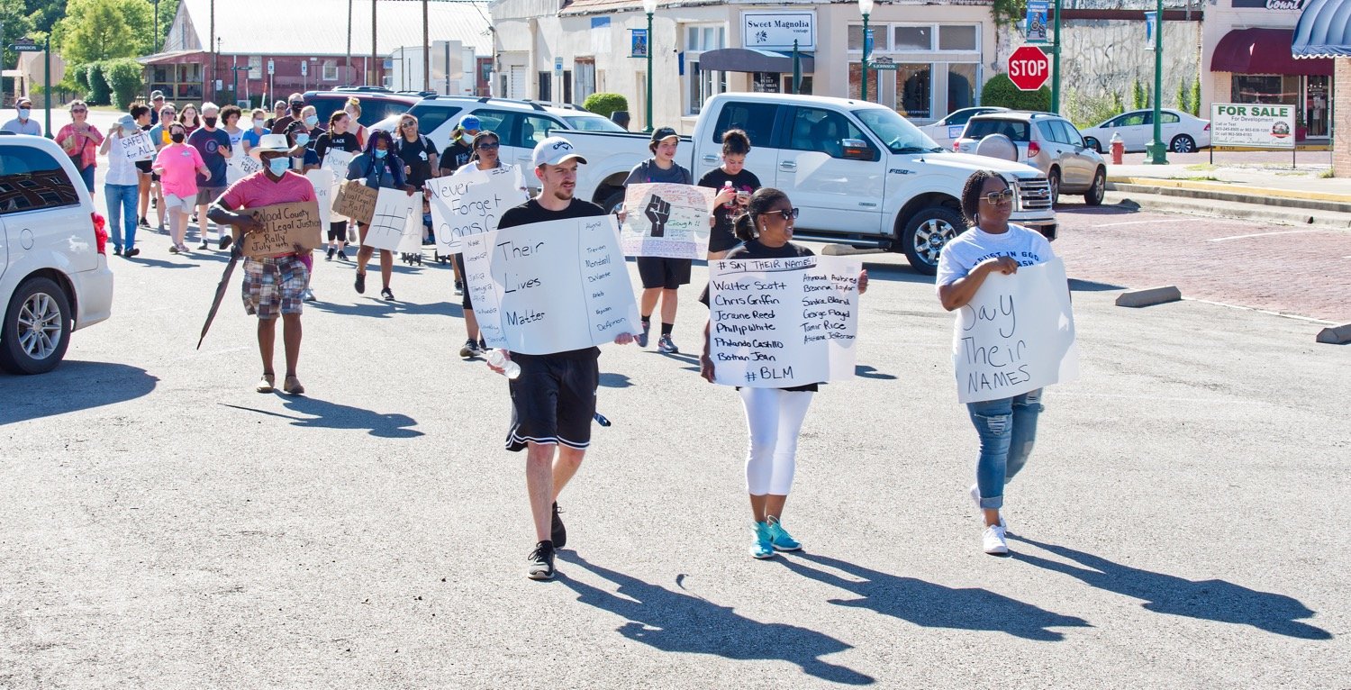 Marchers head east on Commerce St. in Mineola last Thursday afternoon, led by, from left, Hunter Barr, Kelly Wishart and Vanessa Blackwell.
